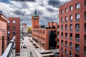 Blick auf eine Stadt mit einem Uhrturm in der Unterkunft Rent like home - Browary Wrocławskie in Breslau