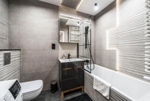 ein Badezimmer mit einem Waschbecken, einem WC und einer Badewanne in der Unterkunft Rent like home - Browary Wrocławskie in Breslau
