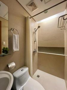 a bathroom with a toilet and a sink and a shower at One Tagaytay Place Private Residences in Tagaytay