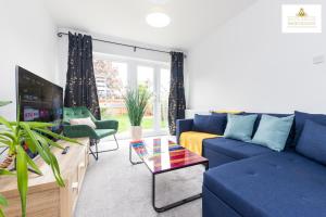 a living room with a blue couch and a tv at 3 Bedroom House in Stevenage By White Orchid Property Relocation Free Paring Wi-Fi Serviced Accommodation in Stevenage