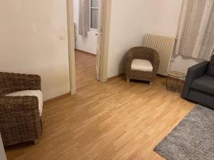 salon z dwoma krzesłami i kanapą w obiekcie Guibert 17 F2 RDC avec petite terrasse w mieście Caudebec-lès-Elbeuf