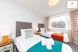 a bedroom with two beds and a window at 3 Bedroom House in Stevenage By White Orchid Property Relocation Free Paring Wi-Fi Serviced Accommodation in Stevenage