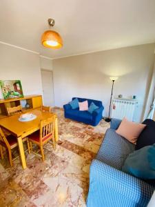 ein Wohnzimmer mit einem Tisch und einem blauen Sofa in der Unterkunft Appartamento elegante a due passi dal lago in Como