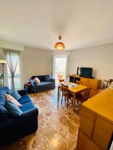 ein Wohnzimmer mit einem blauen Sofa und einem Tisch in der Unterkunft Appartamento elegante a due passi dal lago in Como
