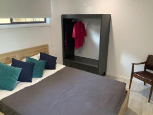 a bedroom with a large bed with blue pillows at Jetty Road Granny Flat in Normanville
