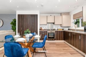 a kitchen with a dining table and blue chairs at NEW Berkley House by Truestays - 3 Bedroom House in Stoke-on-Trent in Etruria