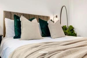 a bed with green and white pillows on it at NEW Berkley House by Truestays - 3 Bedroom House in Stoke-on-Trent in Etruria