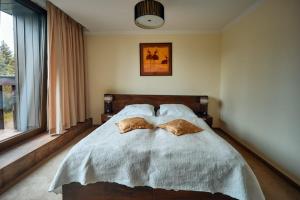 a bedroom with a bed with two pillows on it at President Hotel Montfort in Ždiar