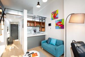 a living room with a blue couch and a kitchen at Busan Studio 202 in Busan