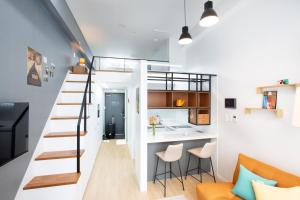 um pequeno apartamento com uma escada e uma sala de estar em Busan Studio 202 em Busan