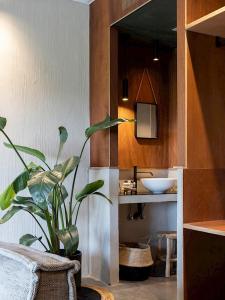 een badkamer met een wastafel en een potplant bij BBruT in Brugge