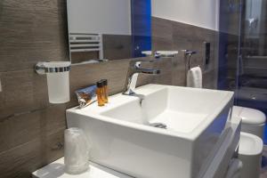 a bathroom with a white sink and a mirror at Luxmarì Hotel & Spa in Castellammare del Golfo