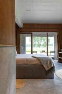 a bedroom with a large bed and a large window at BBruT in Bruges