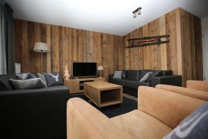 Sala de estar con 2 sofás y TV en Ferienwohnung Bergwiese, en Winterberg