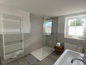 ein Bad mit einer Dusche und einem Waschbecken in der Unterkunft BERGLAGE - Das UrlaubZuhause - Ferienhäuser in Braunlage