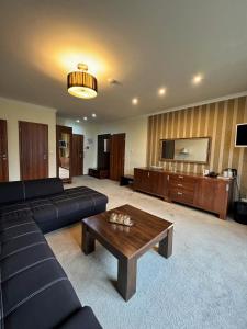 ein Wohnzimmer mit einem Sofa und einem Couchtisch in der Unterkunft President Hotel Montfort in Ždiar