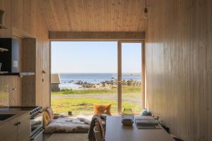 a kitchen with a large window with a view of the ocean at The Longhouse at Lista in Farsund