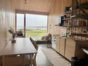 a kitchen with a table and a large window at The Longhouse at Lista in Farsund