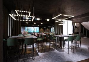 a bar with green chairs and tables in a restaurant at Magic Hotel & Apartments Kløverhuset in Bergen