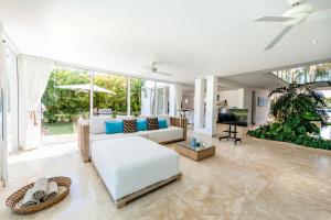 a living room with a white couch and a large window at Luxury Villa Waterfall with Private Pool, BBQ & Maid in Punta Cana