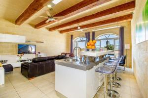 a kitchen and living room with a bar and a couch at Hanini Holiday Home in Qala