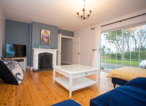 a living room with a white table and a fireplace at Saltee View Holiday Home in Kilmore