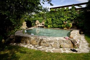 einen Pool in einem Garten mit einer Steinmauer in der Unterkunft Brugarolas Village in Castelltersol