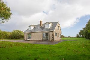 une maison dans un champ avec une pelouse dans l'établissement Saltee View Holiday Home, à Kilmore