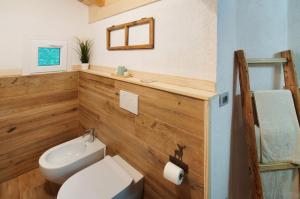 Łazienka z białą toaletą i umywalką w obiekcie Sweet Somma Mountain Lodge 2 w mieście San Guglielmo