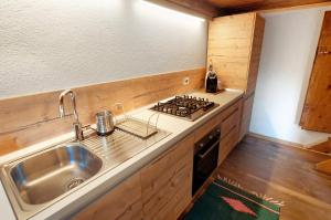 a kitchen with a sink and a stove at Sweet Somma Mountain Lodge in San Guglielmo