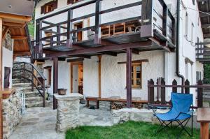 a house with a balcony and a blue chair at Sweet Somma Mountain Lodge in San Guglielmo