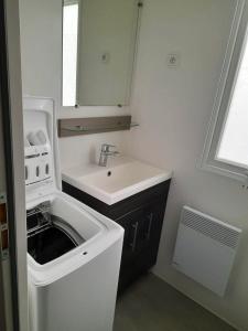a small bathroom with a sink and a mirror at Bungalow charmant au cœur de Les Mathes avec piscine partagée in Les Mathes