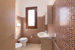a bathroom with a toilet and a sink and a mirror at Appartamento Custonaci Uno in Custonaci
