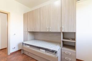 a bedroom with wooden cabinets and a bed in it at Appartamento Custonaci Uno in Custonaci