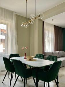 リヴィウにあるLEOGRAND VIP Apartments on Lesi Ukrainky 7のダイニングルーム(テーブル、緑の椅子付)