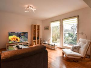 a living room with a couch and a tv at Ferienwohnung Ostseestern in Wiek auf Rügen