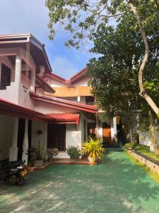 ein Haus mit grünem Rasen davor in der Unterkunft Ceylonima Home Stay in Anuradhapura
