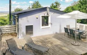 eine Terrasse mit einem Tisch, Stühlen und einem Sonnenschirm in der Unterkunft Ferienhaus Zum Teichtal M in Hainrode