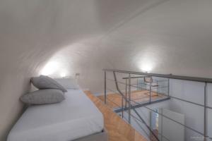 1 dormitorio blanco con 1 cama y escalera en Appartamento Conte Verde 1756 - Storie e Dimore, en Turín