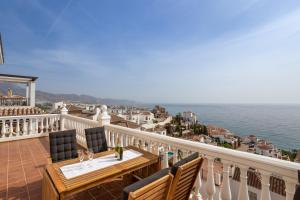 a balcony with a table and chairs and the ocean at Exclusive Villa - Great Sea View in Nerja