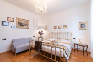 a bedroom with a bed and a chair and a chandelier at Casa Dolce Casa in Montepulciano