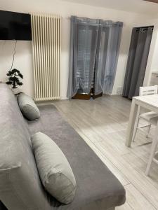uma sala de estar com um sofá e uma mesa em Appartamento "IL PORTICO" A SOLI 8 CHILOMETRI DA IMOLA E 7 CHILOMETRI DA FAENZA em Castel Bolognese