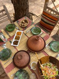 una mesa con tazones y platos de comida. en Maison d'Hôtes Irocha, en Tisseldeï