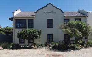 a white building with a sign on it at Blouberg Manor in Bloubergstrand