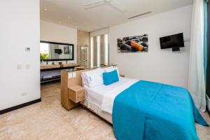 een slaapkamer met een groot bed en een televisie bij Luxury Villa Waterfall with Private Pool, BBQ & Maid in Punta Cana