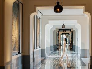 a woman walking down a hallway in a building at Andaz Xiamen in Xiamen