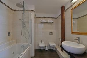 a bathroom with a sink and a shower and a toilet at Hotel Le Chevalier in Taormina