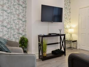 a living room with a tv on a wall at The Bungalow in Thornton