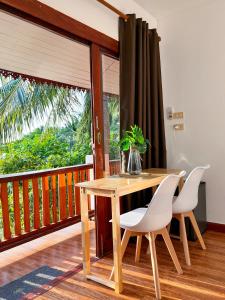 a wooden table and chairs on a balcony at Secret Place Hotel and Restaurant in Haad Yao