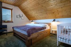 a bedroom with a bed and a wooden ceiling at TATRYSTAY Family Villa Rosa in Stará Lesná